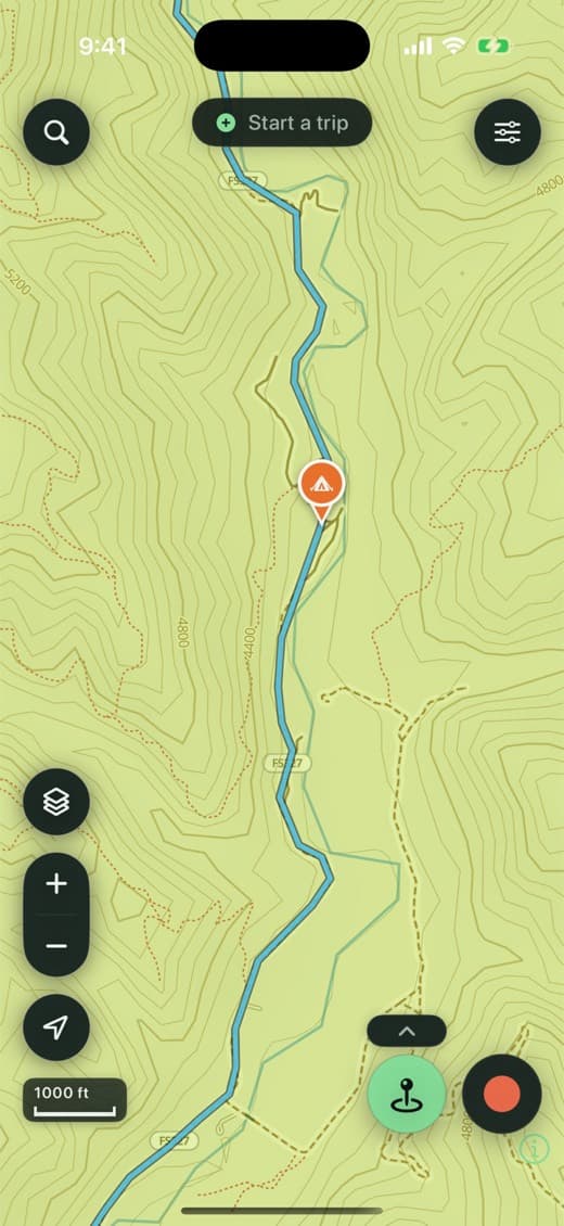 Second Kick Maps on-device topo base showing labelled contour lines, terrain shading and numbered forest roads, with a ridden track following a forest road and a campsite pin dropped where the rider camped